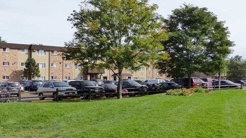 A parking lot with cars and apartment buildings in the background.
