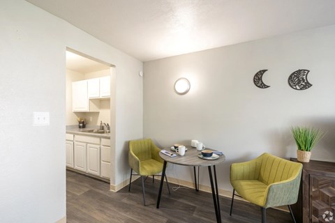 A small dining area with a table and two chairs.