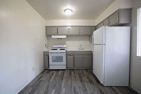 A kitchen with a white fridge and a white oven.