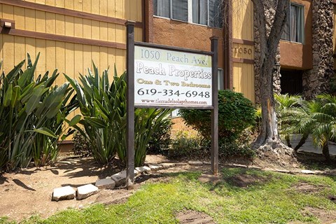 Property sign in landscape near building