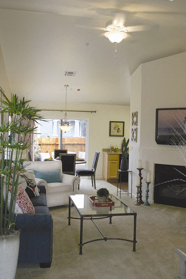 Two BR Apartments in Reno NV - Bungalows at Sky Vista - Living Room with Couch, Chair, Coffee Table, Fire Place, and Ceiling Fan.