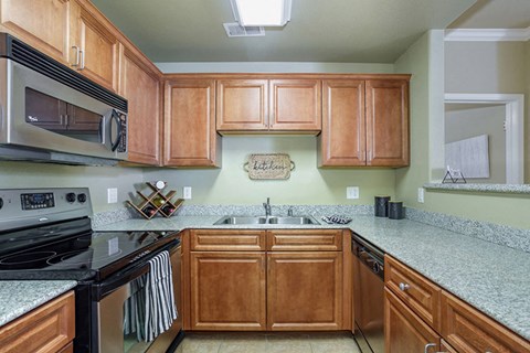 a kitchen with granite counter tops and wooden cabinets