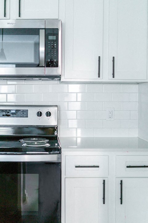 A kitchen with a stove and microwave.
