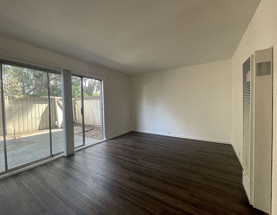 North Oakland, CA Apartments for Rent - 225 Clifton - Living Room with Wood-Plank Flooring and a Sliding Glass Door to a Private Patio