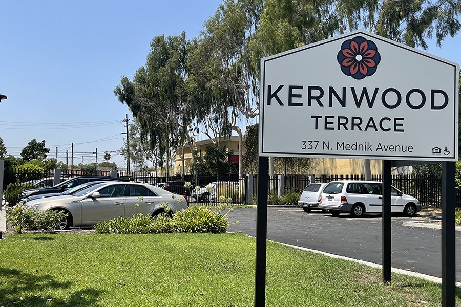 Community sign next to grass and parking
