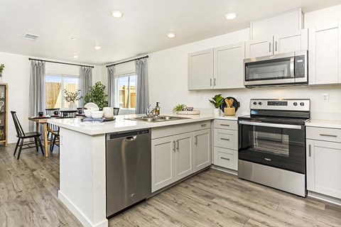 a white kitchen with a stove and a sink