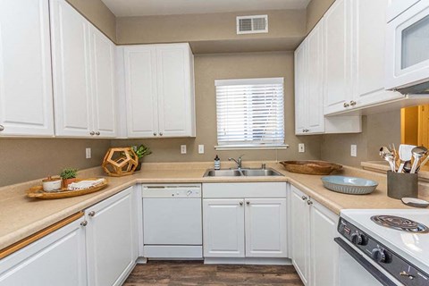 a kitchen with white cabinets and a stove and a sink