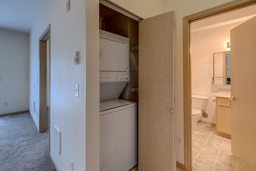 A white dishwasher is in a kitchen pantry.