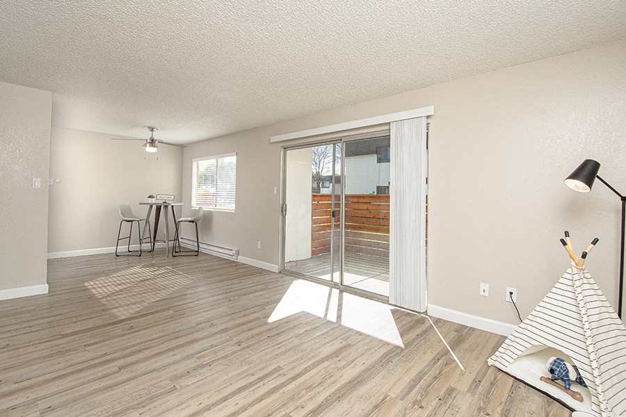 Apartments near Sonoma State University - The Lenox - Open Plan Living Room with Breakfast Nook, Sliding Patio Doors, and Wood Plank Flooring