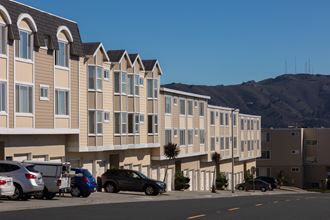 Dale City, CA Apartments-Terrace View-Buidings with garages, paved walkways, greenery, and roads