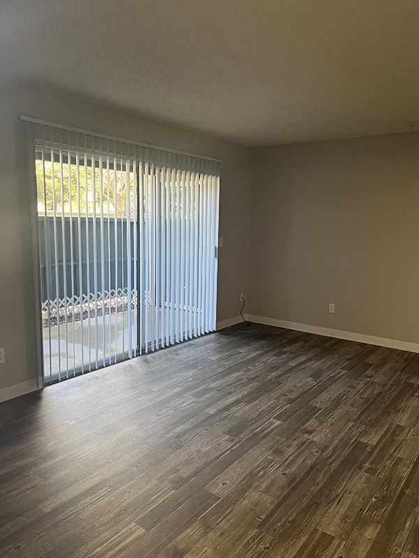 a room with a sliding glass door and hardwood floors
