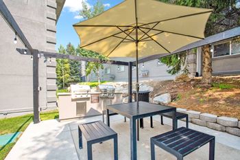 a patio with a table and chairs with an umbrella at Mountain Run Apartments, Orem, UT 
