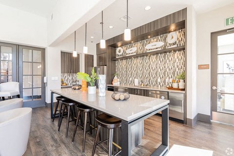 a large kitchen with a counter and bar stools