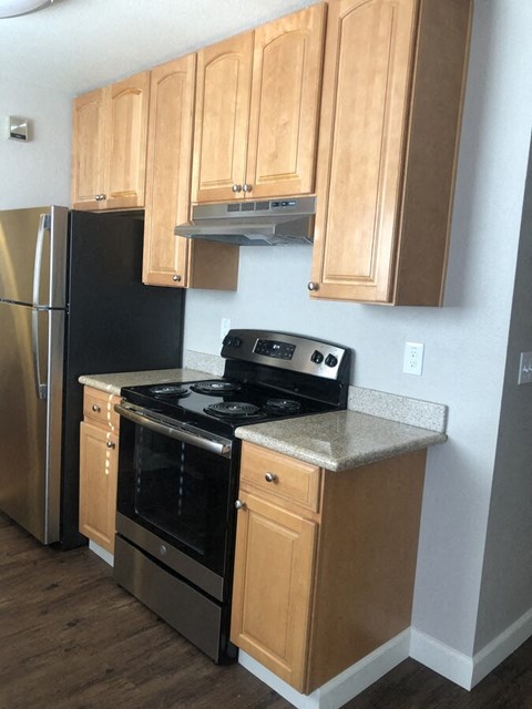 A kitchen with wooden cabinets and a black stove top oven.