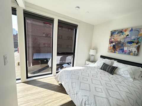 a bedroom with a bed and two large windows at DOCK 59 APARTMENTS, PORTLAND, OR, 97209