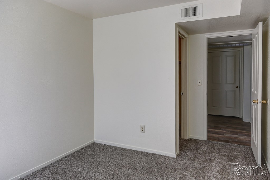 a bedroom with white walls and a carpeted floor