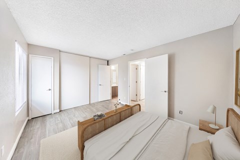 a bedroom with a large bed and white walls and white doors