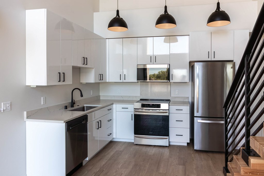 a kitchen with white cabinets and stainless steel appliances