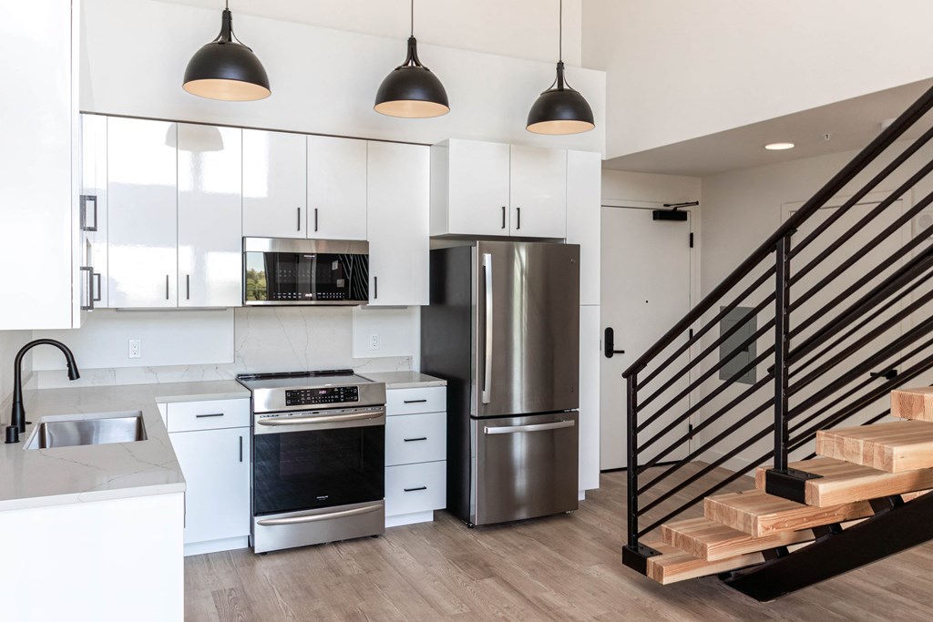 a kitchen with white cabinets and a stainless steel refrigerator