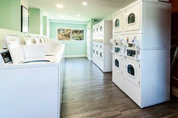 a laundry room filled with white appliances and washers and dryers at Mountain Run Apartments, Orem, UT 84058