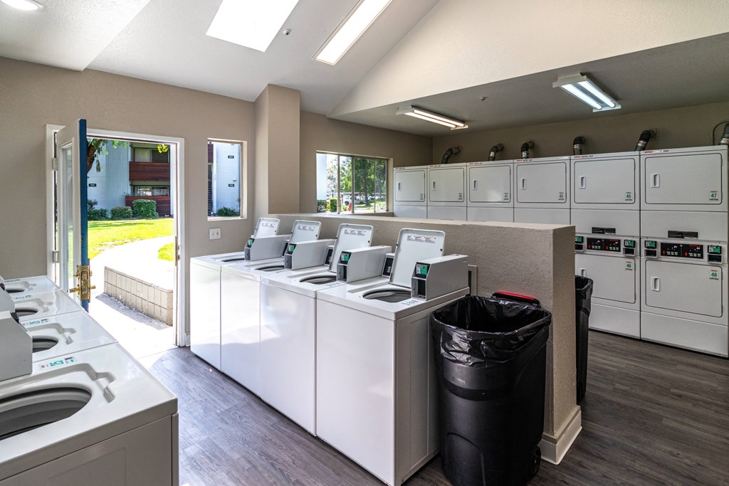 a community laundry room with washers and dryers and a door to a bedroom