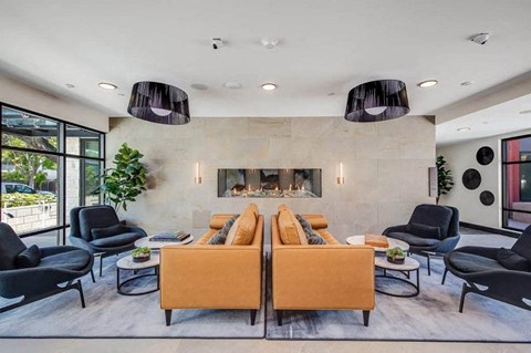 a living room with a couch and chairs in front of a fireplace