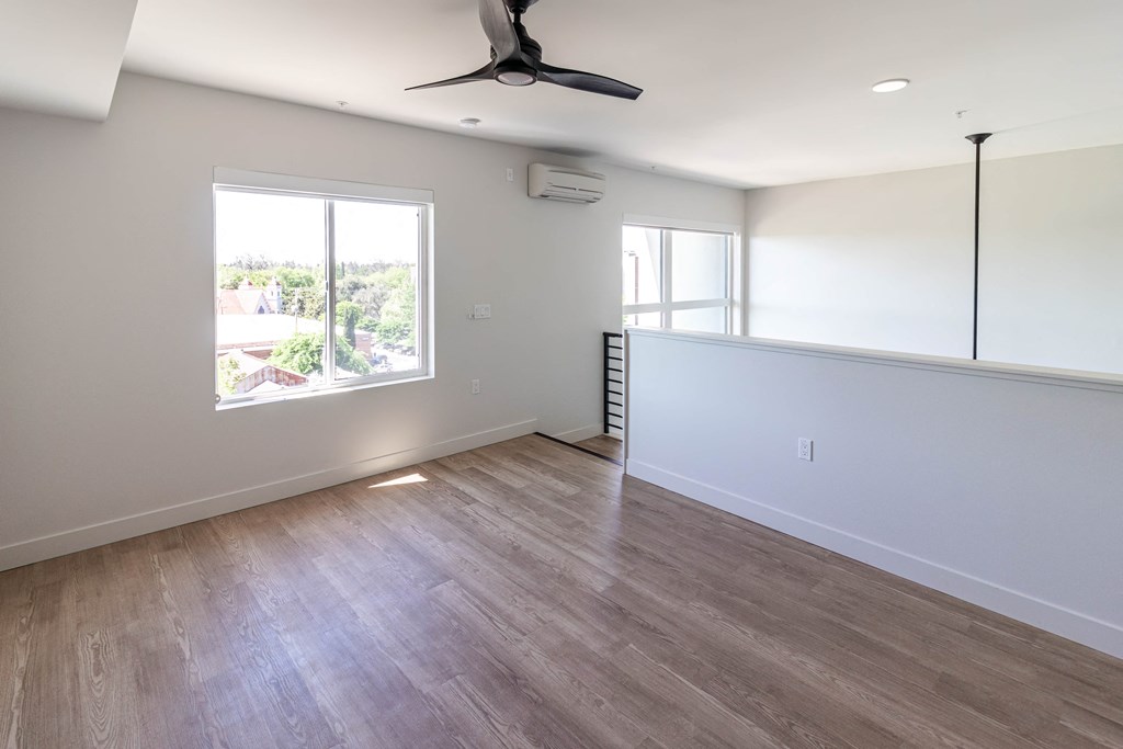 an empty living room with white walls and a window