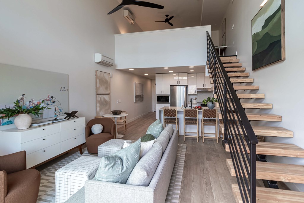 a living room with a couch and a table and stairs