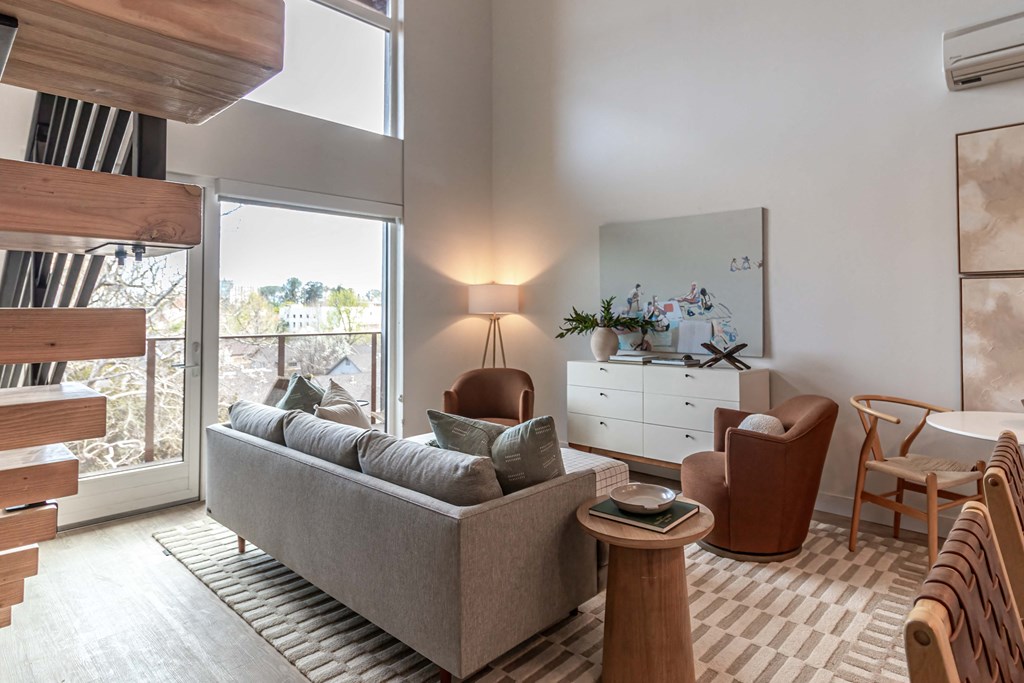 a living room with a couch and chairs and a large window