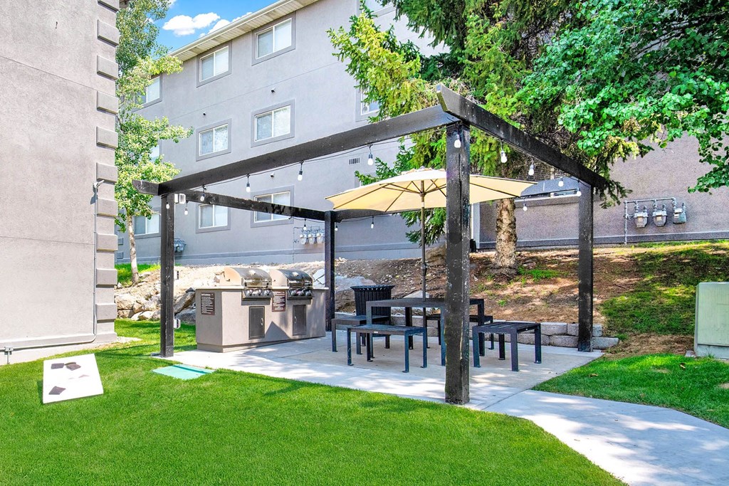 a patio with a table and chairs under a canopy a patio with a table and chairs under a canopy at Mountain Run Apartments, Orem, 84058