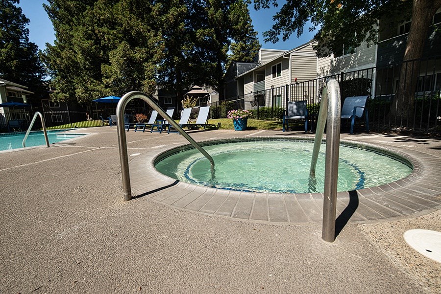 a hot tub in a pool with a metal fence around it