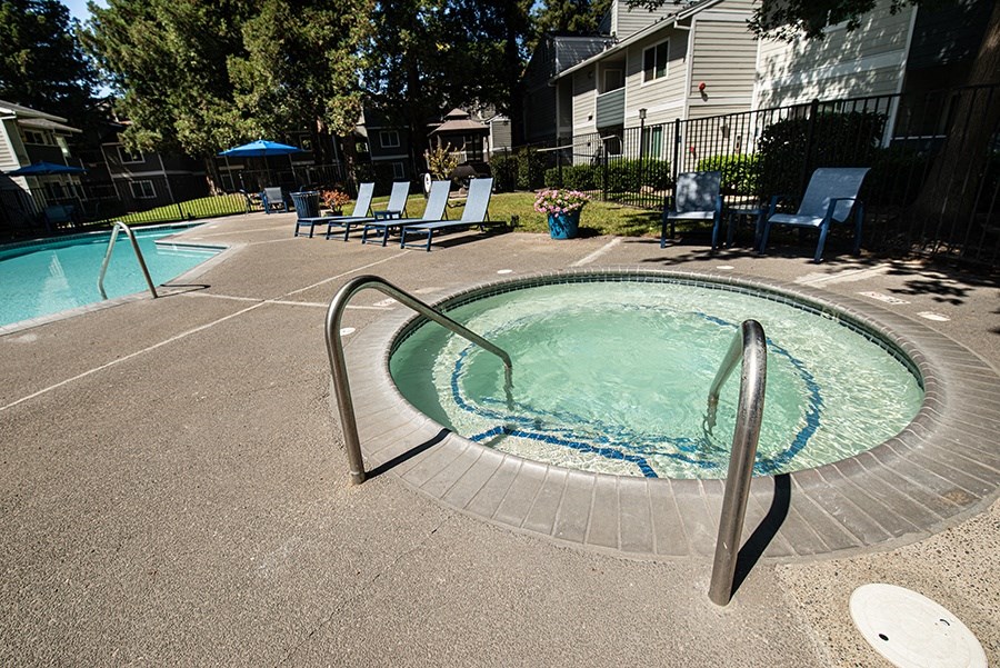 a hot tub with chairs around it in a pool