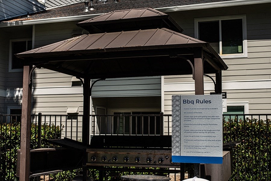 a sign for a bbq rules sign in front of a house
