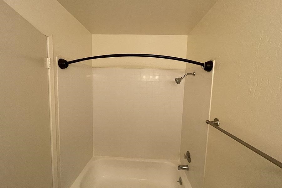 a white bath tub sitting next to a shower
