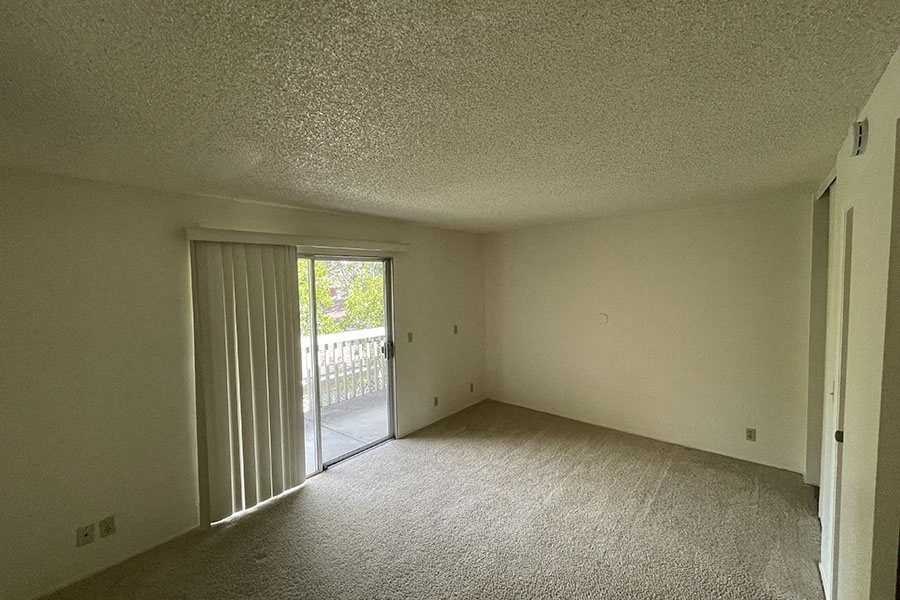 a bedroom with a sliding glass door leading to a balcony