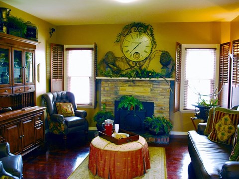 a living room with a fireplace and a clock on the wall
