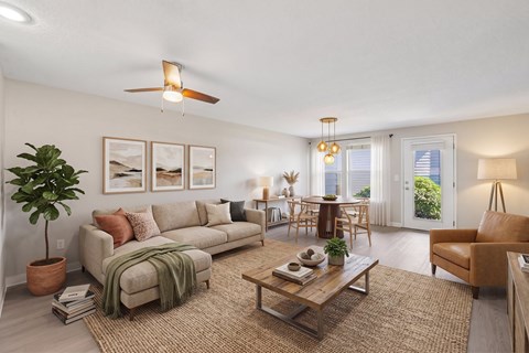 A living room with a couch, a coffee table, and a ceiling fan.