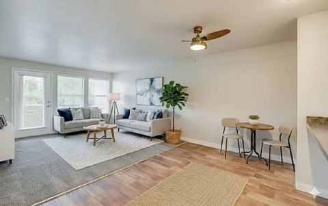 A living room with a grey rug and a wooden coffee table.