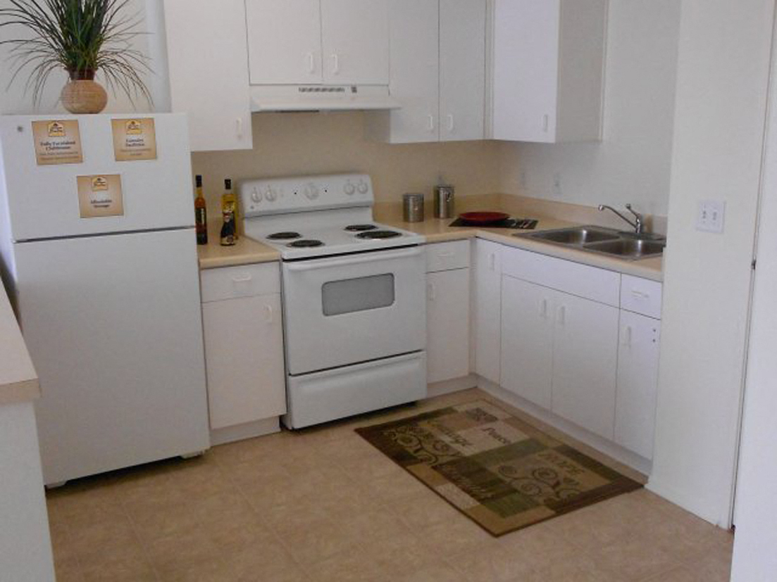 A kitchen with white appliances and cabinets.