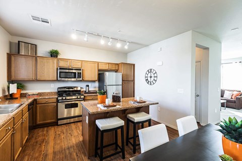 a kitchen with wooden cabinets and a table with chairs