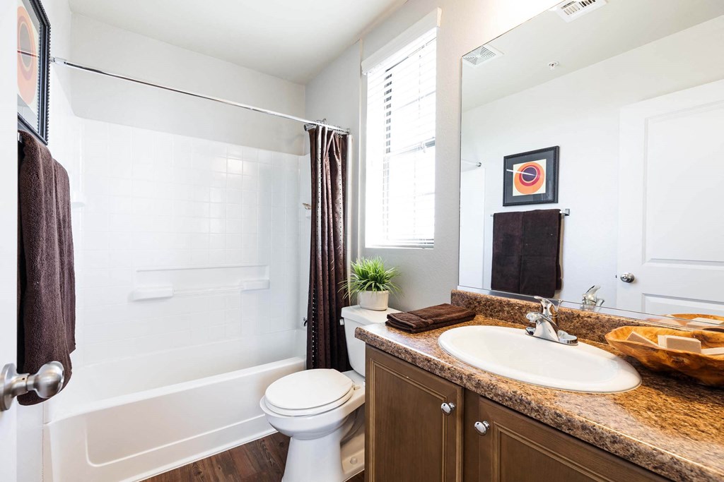 A bathroom at Everett with a sink toilet and shower. at EVERETT APARTMENT HOMES, Las Vegas, 89113
