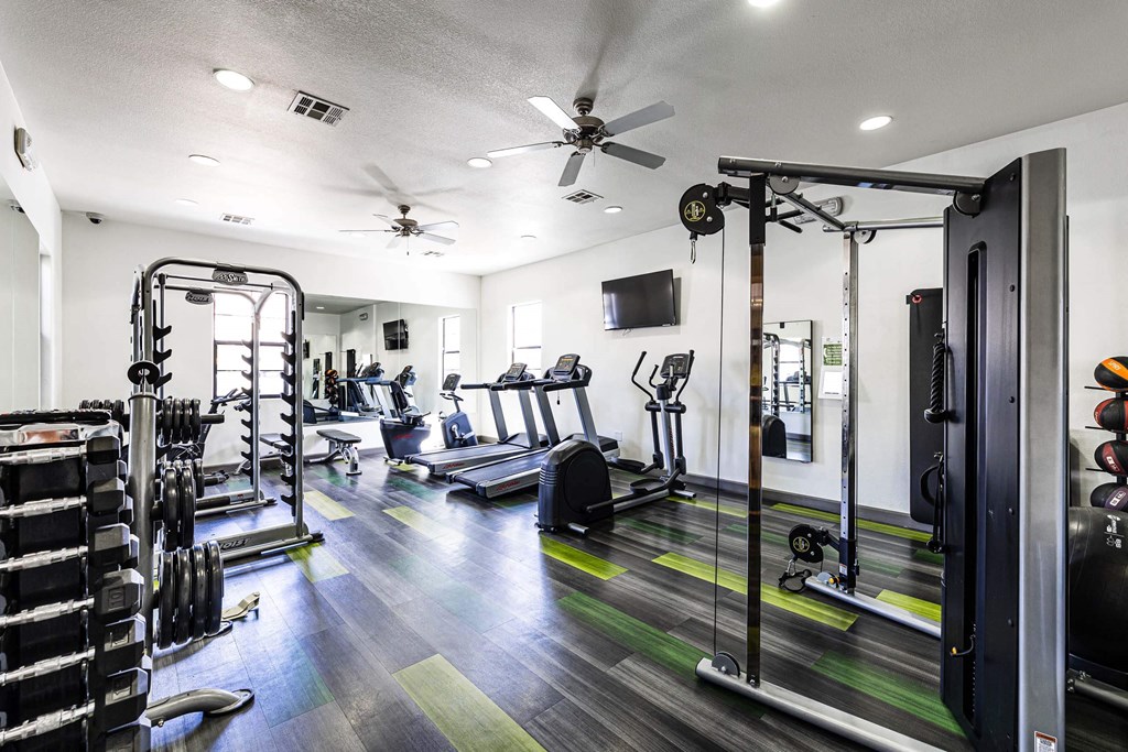 gym with weights and cardio equipment and a tv at EVERETT APARTMENT HOMES, Las Vegas