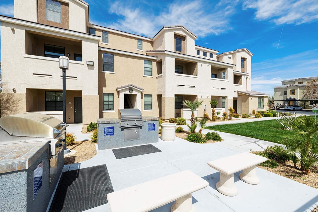 A view of an outdoor patio with a grill and picnic table  at EVERETT APARTMENT HOMES, Las Vegas, 89113