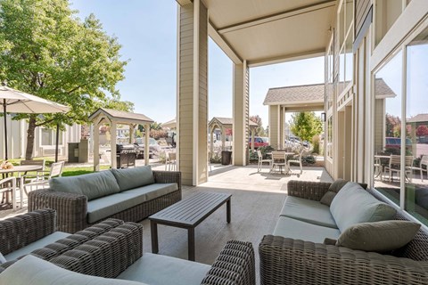 A patio with a table and chairs is covered by a roof.