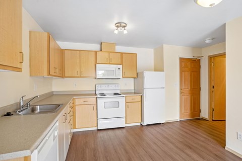 A kitchen with wooden cabinets and white appliances.