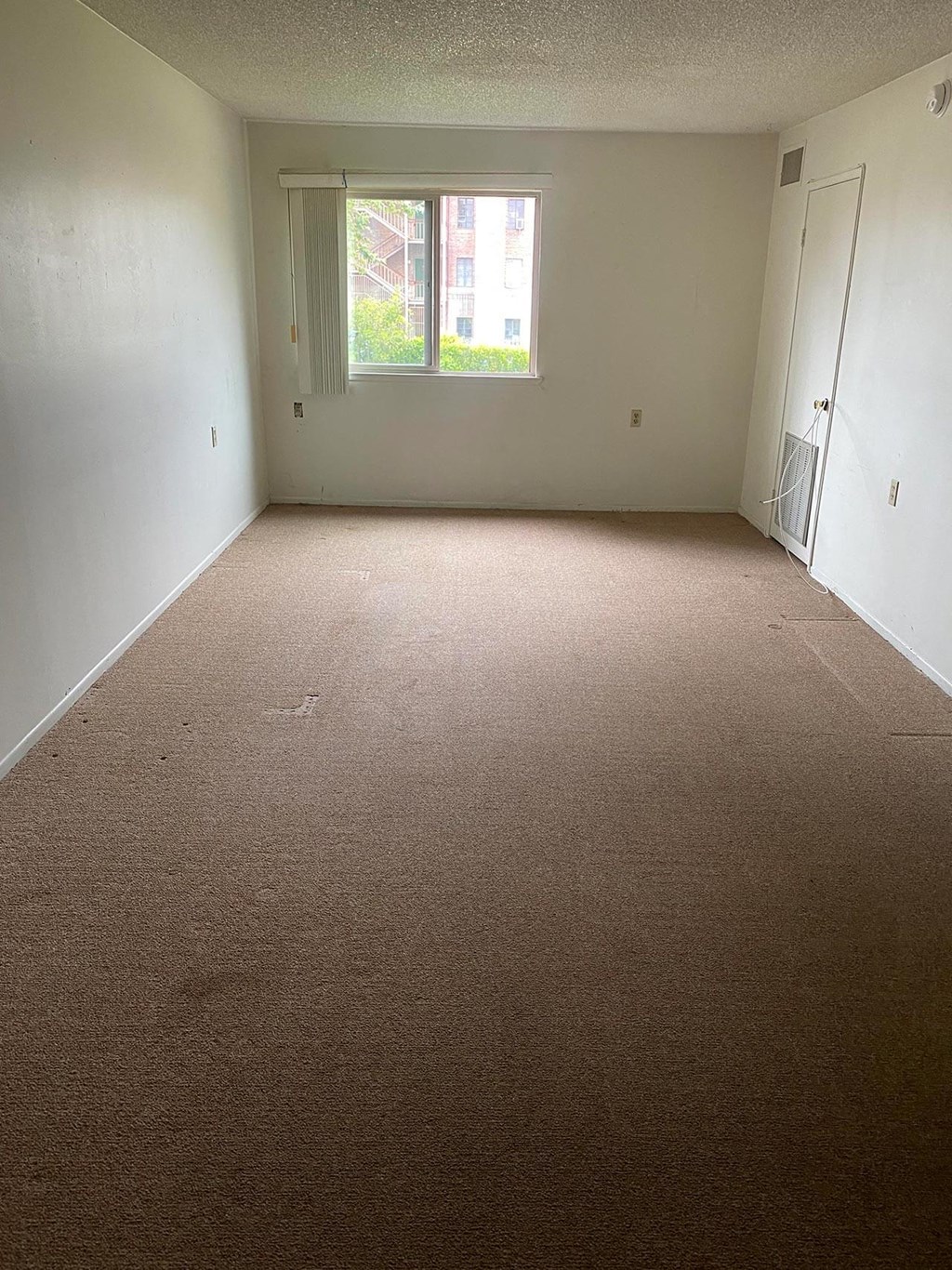 a room with a carpeted floor and a window