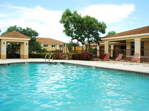 a swimming pool in front of a house with a resort style pool
