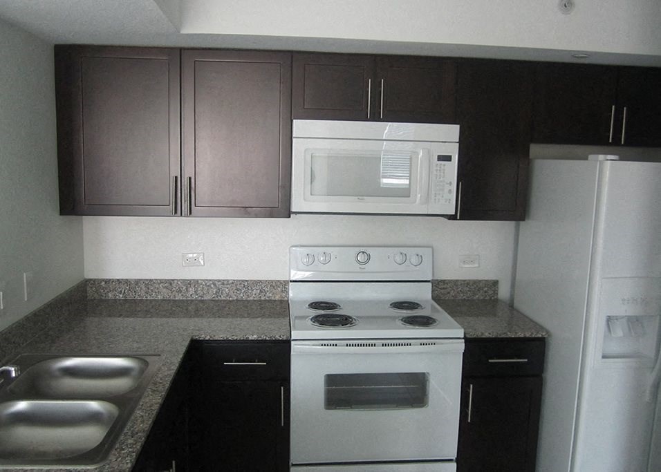 Mirabella Apartments kitchen area with white appliances and bar top for seating at Mirabella Apartments, Princeton, Florida