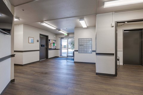 a lobby with a wood floor and white walls and doors