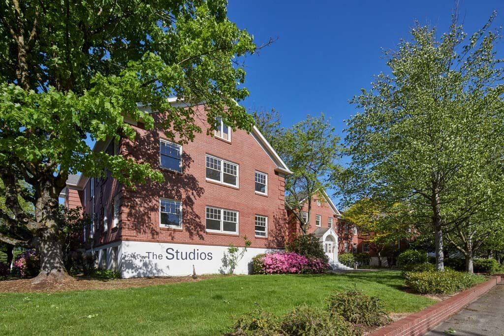 a large brick building with a sign that reads the studios at MILEPOST 5 Apartments, PORTLAND, 97213